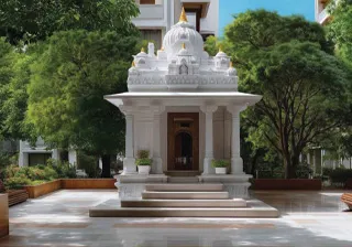 Elegant white temple pavilion with intricate architectural details, surrounded by lush trees and landscaped grounds.